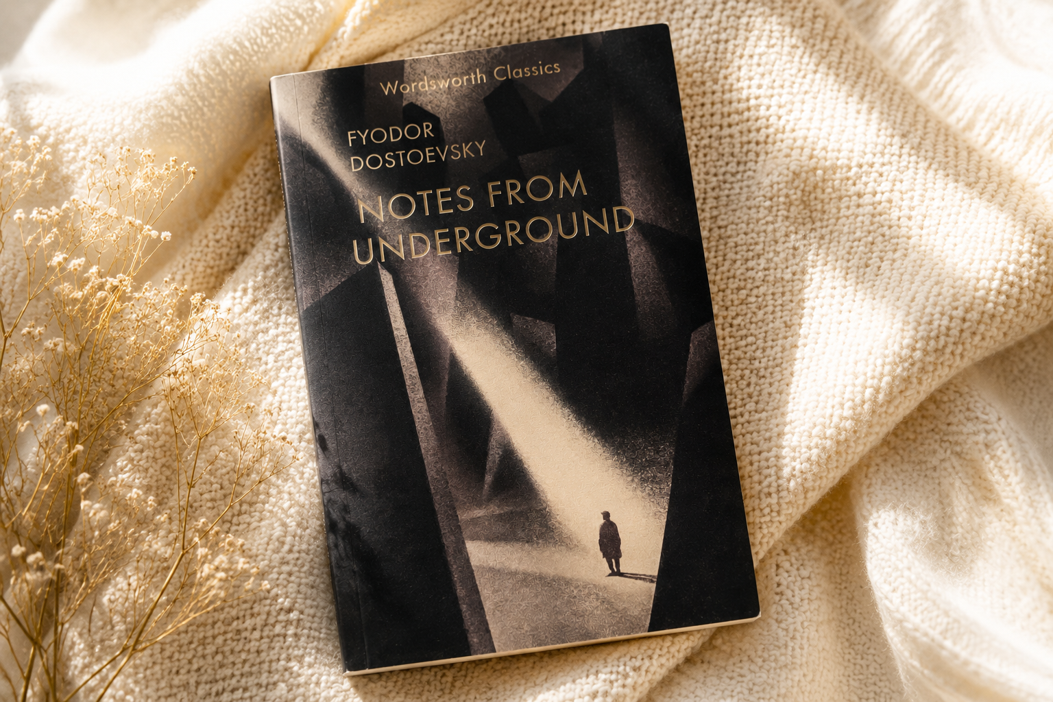Notes from Underground book on a cream knit blanket.
